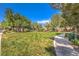 Well-manicured community park with lush green grass, mature trees, and a walking path for residents' enjoyment at 409 Lake Windemere St, Las Vegas, NV 89138