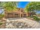 Charming home featuring an attached three-car garage, beautiful stone accents, and manicured landscaping at 409 Lake Windemere St, Las Vegas, NV 89138