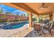 Inviting covered outdoor living space featuring a pool, lounge chairs, and beautifully landscaped backyard at 409 Lake Windemere St, Las Vegas, NV 89138