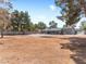 Wide-angle view of the backyard with an area for entertaining, mature trees and large parking area at 4620 Pacer Ave, North Las Vegas, NV 89031