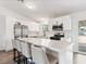 Updated kitchen features stainless appliances, white cabinets, and a large island with bar stool seating and pendant lighting at 4620 Pacer Ave, North Las Vegas, NV 89031