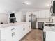 Bright kitchen features stainless appliances, white cabinets, an island, and a black brick fireplace adjacent to the kitchen at 4620 Pacer Ave, North Las Vegas, NV 89031