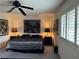 This bedroom features a ceiling fan, a patterned bedspread, and a window with shutter blinds at 4662 Kelly Barry Way, Las Vegas, NV 89121