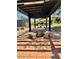 A charming patio area with a pergola roof, tables, and benches at 4662 Kelly Barry Way, Las Vegas, NV 89121
