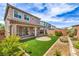 Inviting backyard with artificial grass, brick trimmed flowerbeds, covered patio, and low maintenance desert landscaping at 48 Verde Rosa Dr, Henderson, NV 89011