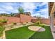 Manicured backyard featuring artificial grass, flowerbeds with attractive landscaping, and a brick privacy wall at 48 Verde Rosa Dr, Henderson, NV 89011
