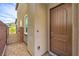 Exterior side view of home showing private gate and covered front porch with a wooden door at 48 Verde Rosa Dr, Henderson, NV 89011