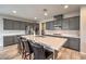 Stylish kitchen with stainless appliances, gray cabinetry and large island with barstool seating at 48 Verde Rosa Dr, Henderson, NV 89011
