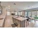 Open-concept living area with wood-look flooring, gray cabinetry, and backyard patio access at 48 Verde Rosa Dr, Henderson, NV 89011