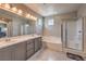 Bright bathroom featuring a double sink vanity, soaking tub, and glass enclosed shower at 48 Verde Rosa Dr, Henderson, NV 89011