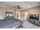 Bright main bedroom with a ceiling fan, dresser, and TV; neutral color scheme at 48 Verde Rosa Dr, Henderson, NV 89011