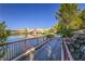 Peaceful view of a lake, bridge, and buildings, bordered by a wrought iron fence and stone path at 48 Verde Rosa Dr, Henderson, NV 89011