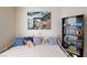 Cozy bedroom features a white metal bed, colorful decorative pillows, and a bookcase filled with items at 50 Belle La Blanc Ave, Las Vegas, NV 89123