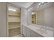 Bright bathroom features double sinks, large mirror, and walk-in closet with custom wood shelving at 50 E Serene Ave # 420, Las Vegas, NV 89123