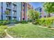 Landscaped complex exterior with lawn, benches, decorative trees, and colorful building facade at 50 E Serene Ave # 420, Las Vegas, NV 89123