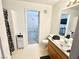 Bathroom with white tile floors and wood cabinet sink and shower at 5024 Starfinder Ave, Las Vegas, NV 89108