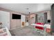 Bedroom with a TV, workstation and lots of sunlight from a window, with convenient access to an adjacent bathroom at 5024 Starfinder Ave, Las Vegas, NV 89108