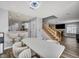 Open-concept dining area with stairs, a modern white table, and wood-look floors at 5024 Starfinder Ave, Las Vegas, NV 89108