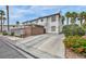 Exterior view of a two-story house with a carport, desert landscaping, and flowers at 5024 Starfinder Ave, Las Vegas, NV 89108