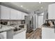 Modern kitchen with stainless steel appliances, granite countertops, and sleek white cabinets at 5024 Starfinder Ave, Las Vegas, NV 89108