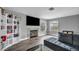 Living room with a fireplace, TV, arched windows, and a gray sectional sofa at 5024 Starfinder Ave, Las Vegas, NV 89108