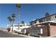 Beautiful street view of white townhomes, desert landscaping and palm trees under a bright blue sky at 5024 Starfinder Ave, Las Vegas, NV 89108