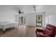 Bedroom with hardwood floors, a ceiling fan, a red chair, and access to the backyard at 530 Tam O Shanter, Las Vegas, NV 89109