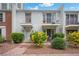 Inviting townhome featuring dual balconies, a brick pathway, blossoming shrubs, and exterior lighting at 530 Tam O Shanter, Las Vegas, NV 89109