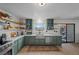 Stylish kitchen with stainless appliances, green cabinets, open shelving, and stainless steel sink at 530 Tam O Shanter, Las Vegas, NV 89109