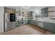 Modern kitchen featuring green cabinetry, stainless steel appliances, and open shelving at 530 Tam O Shanter, Las Vegas, NV 89109