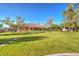 Spacious backyard with a large lawn, mature trees, and a charming home exterior at 5701 Mary Lou St, Pahrump, NV 89061