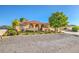 A single story home with a terra cotta colored roof, arched entryway and lush landscaping at 5701 Mary Lou St, Pahrump, NV 89061