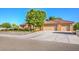 A beautiful home with a terra cotta roof, arched entryway, three car garage and desert landscaping at 5701 Mary Lou St, Pahrump, NV 89061