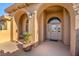 Front porch with an arched entry, accent lighting, double doors and terra cotta colored tile at 5701 Mary Lou St, Pahrump, NV 89061