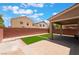 Backyard featuring a covered patio, brick pavers, turf, and brick wall at 6412 Dimatteo St, Las Vegas, NV 89148