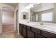 Bathroom featuring dual sinks, a large mirror, and views into the bedroom and shower at 6412 Dimatteo St, Las Vegas, NV 89148