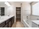 Bathroom featuring dual sinks, a soaking tub, and a walk-in closet at 6412 Dimatteo St, Las Vegas, NV 89148