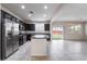 Spacious kitchen with stainless steel appliances, dark cabinetry, an island, and tile floors at 6412 Dimatteo St, Las Vegas, NV 89148