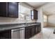 Close-up of kitchen features, stainless steel dishwasher, and sink with overhead cabinets and counters at 6412 Dimatteo St, Las Vegas, NV 89148