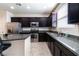 Modern kitchen featuring stainless steel appliances, granite countertops, and dark cabinetry at 6412 Dimatteo St, Las Vegas, NV 89148