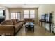 Cozy living room with tile floors, neutral walls, comfortable seating, and lots of natural light at 6412 Dimatteo St, Las Vegas, NV 89148