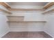Spacious walk-in closet featuring wood shelving and hanging rods for optimal storage and organization at 6412 Dimatteo St, Las Vegas, NV 89148