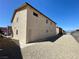 A two-story house featuring stucco siding, a back entrance door, gravel landscaping, and a fenced yard at 6968 Hopkins Dr, Las Vegas, NV 89156