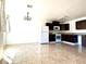 Open kitchen featuring tile flooring, white appliances, dark wood cabinets, and a chandelier light fixture at 6968 Hopkins Dr, Las Vegas, NV 89156