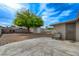 Spacious backyard featuring a concrete patio, mature tree and storage shed at 701 Harvard St, Las Vegas, NV 89107