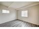 Bright bedroom featuring gray wood-look flooring, white walls, and natural light from two windows at 701 Harvard St, Las Vegas, NV 89107