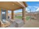 Covered patio with an outdoor seating area, artificial turf, and a shade sail, creating an inviting outdoor space at 7122 Red Gulch St, North Las Vegas, NV 89084