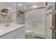 Modern bathroom showcasing a shower with glass doors, white vanity, sink, and decorative wallpaper at 7122 Red Gulch St, North Las Vegas, NV 89084