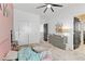 Bright bedroom with a ceiling fan, dresser, pink and white decor, and a door to an adjoining room at 7122 Red Gulch St, North Las Vegas, NV 89084