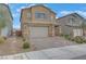 Two-story home with a neutral color scheme, brick-accented facade, two car garage and manicured landscaping at 7122 Red Gulch St, North Las Vegas, NV 89084